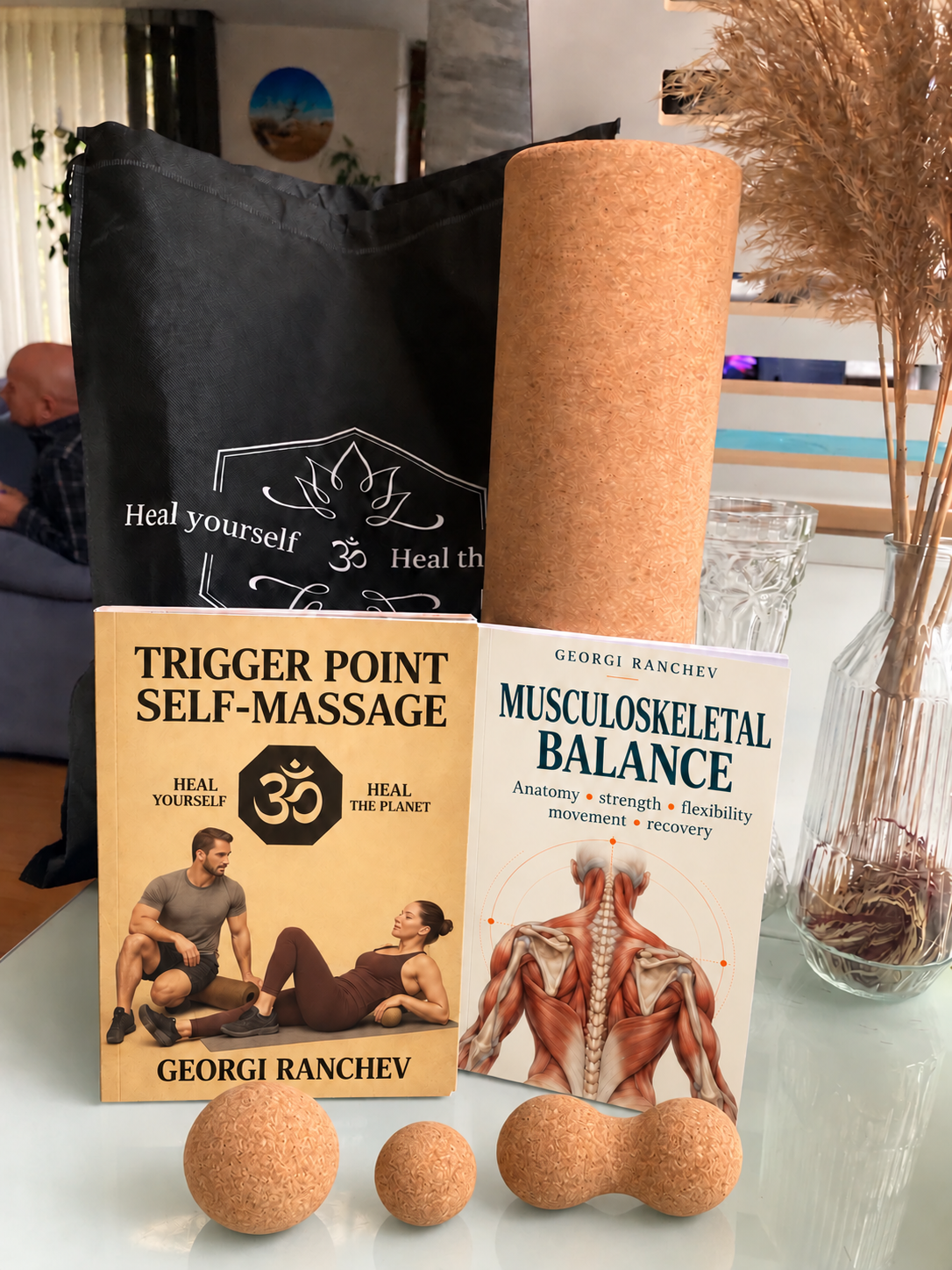 The cork kit, Musculoskeletal Balance and Trigger Point Self-Massage together, with the two A5 books in front of the larger roller and bag
